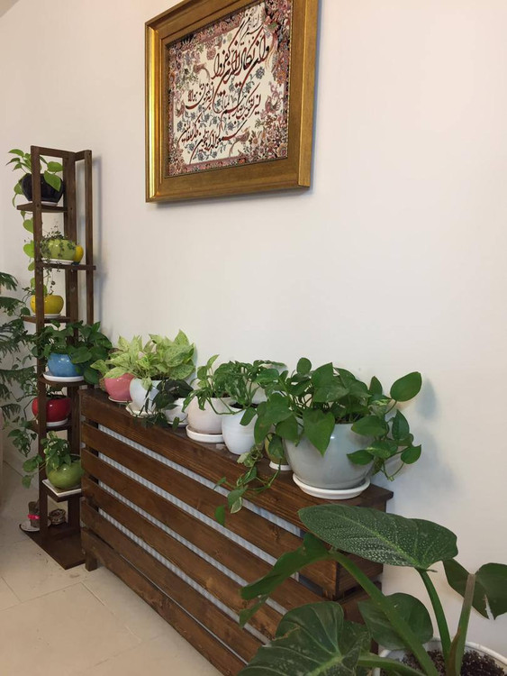 عکس ارسالی مشتری از کاور شوفاژ چوبی کنار استند گلدان