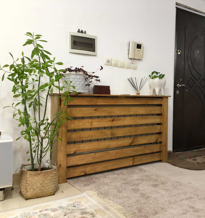 عکس ارسالی مشتری از کاور شوفاژ چوبی کنار گلدان طبیعی